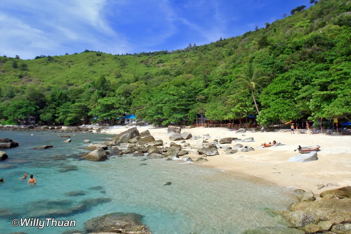 clear water and boulders, the green headland behind