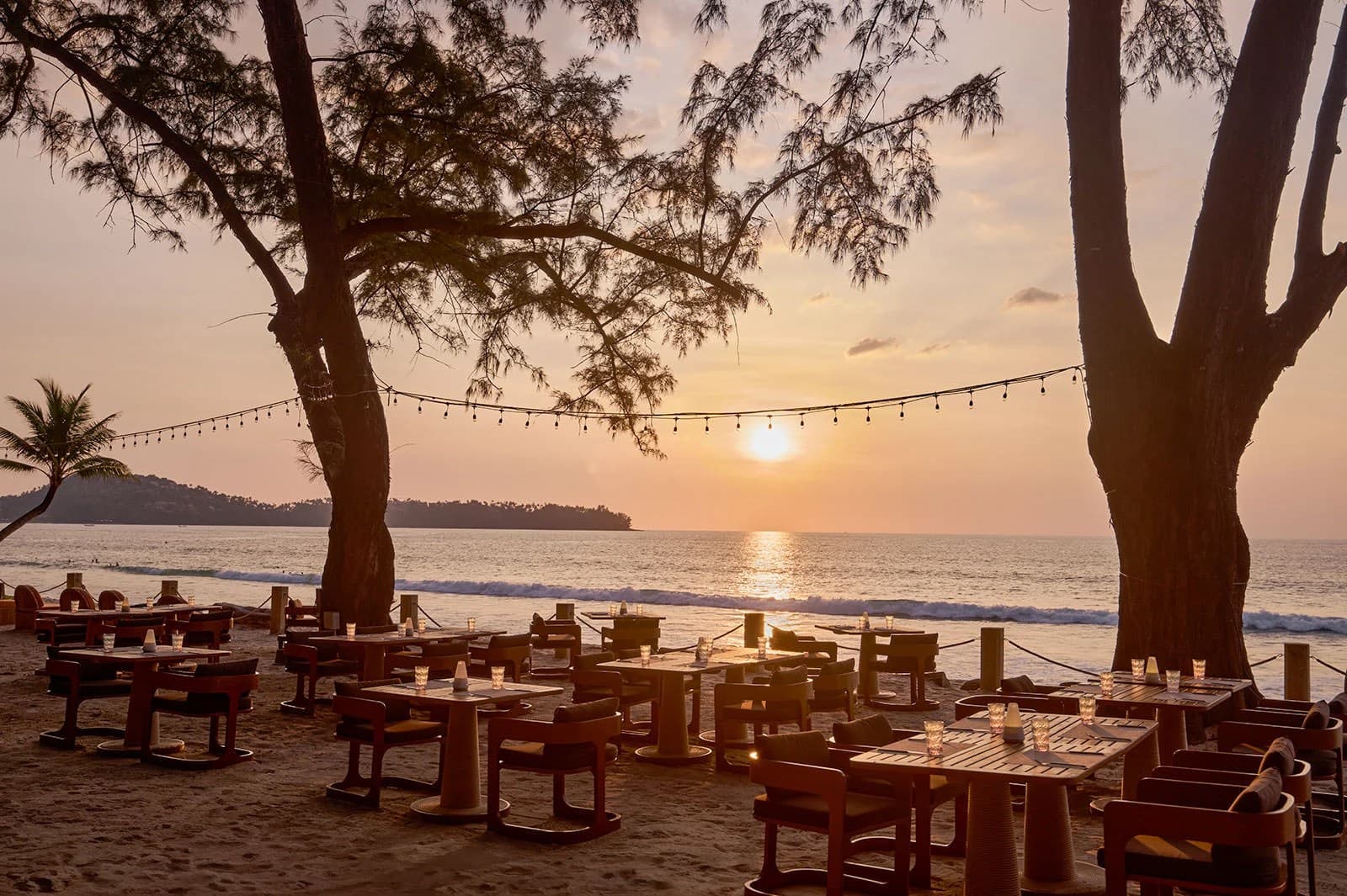Casuarina Beach Club: tables under the trees at sunset