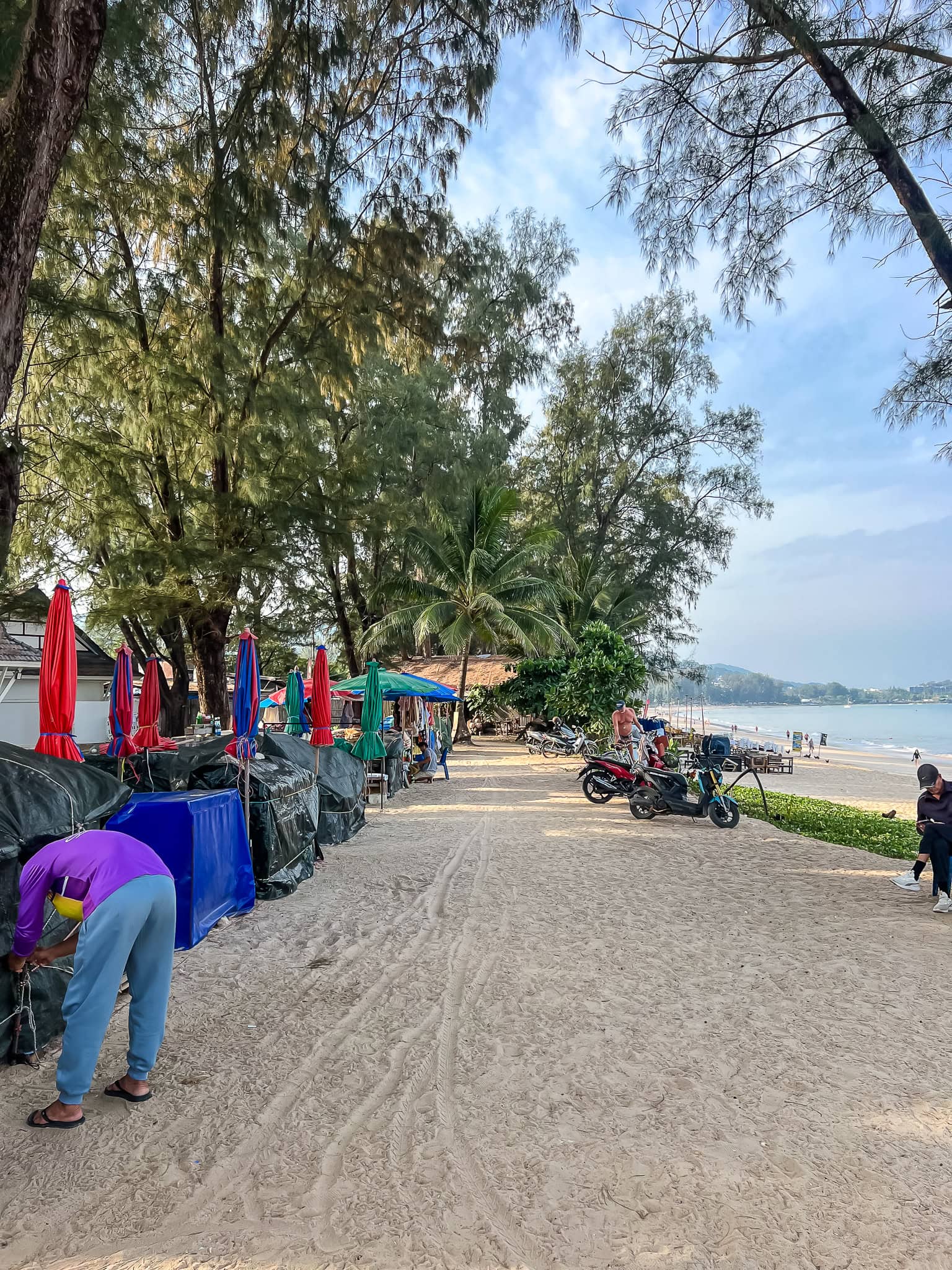 the path behind the sand: umbrellas, a massage mat, a scooter