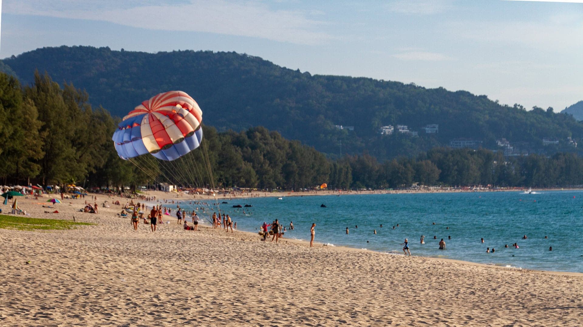 a parasail over the bay, the hills behind