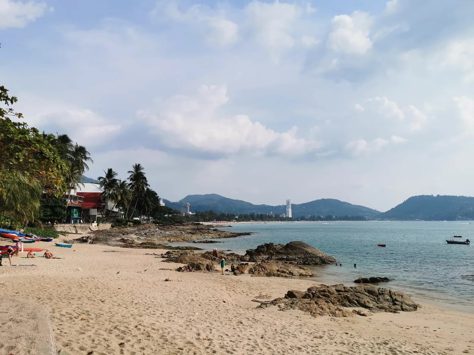 sand and rocks, Patong Bay and its headland behind