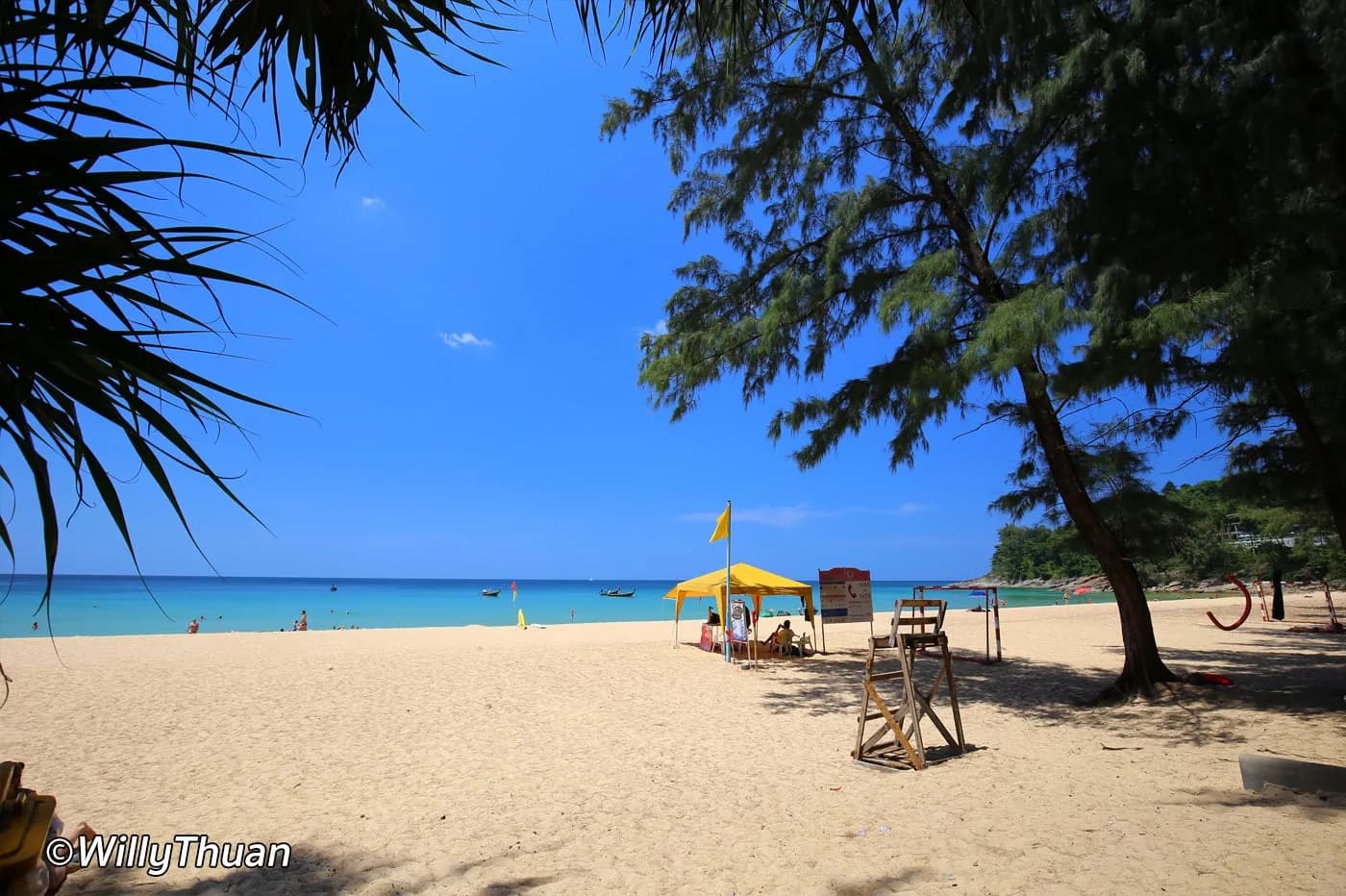 an umbrella and a lounger under the trees