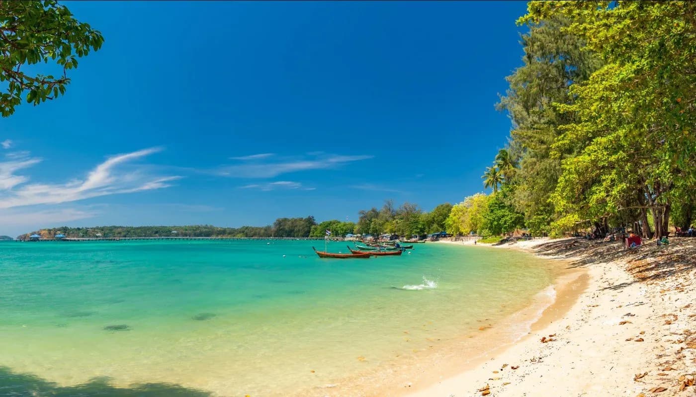 sand, turquoise water and longtail boats