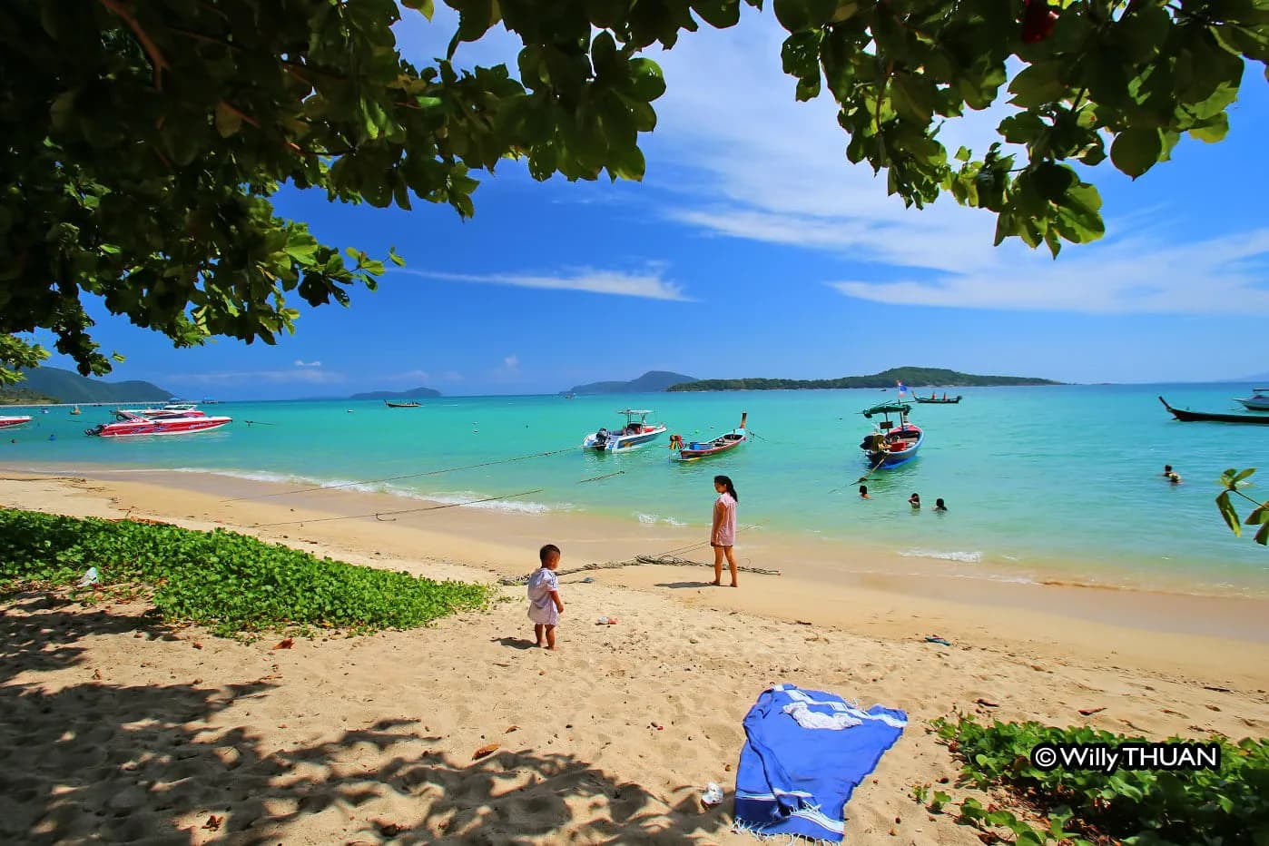the beach with boats moored offshore