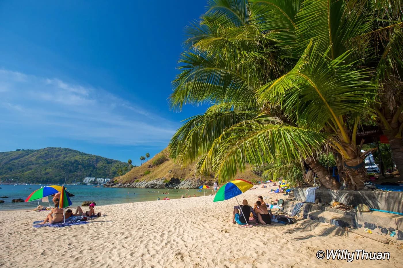 the sand, palms and umbrellas, the islet behind